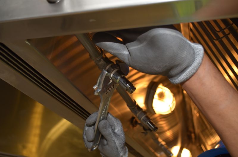 Close-up of a technician using a wrench on pipe fittings